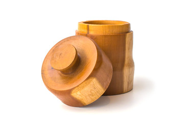 Wooden jar with lid off leaning infront