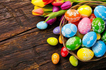 Easter eggs and tulips on wooden planks
