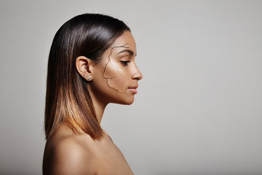 spanish woman's perfil with a crack on a cheek. dry skin concept