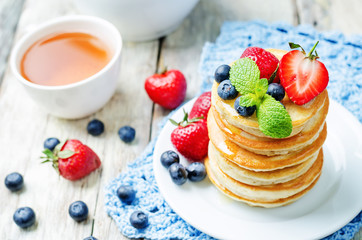 pancakes with honey, strawberries and blueberries