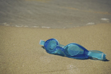 Fototapeta na wymiar Blue goggles on sand