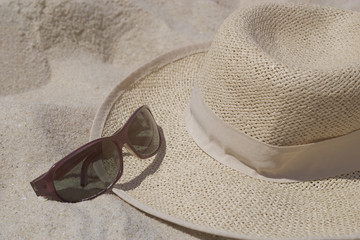 Straw hat with sunglasses on sand