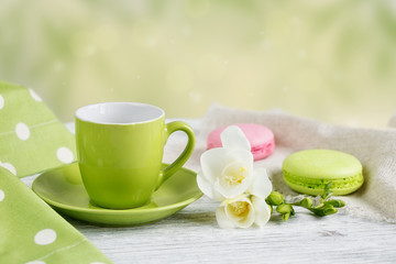 Cup of black coffee, white freesia flowers and sweet pastel fren