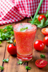 Tomato smoothie on wooden background