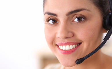 Portrait of beautiful business woman working at her desk with headset and laptop