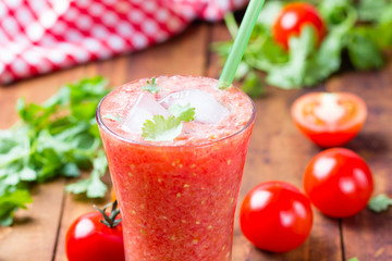 Tomato smoothie on wooden background
