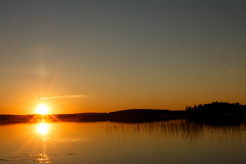 Fototapeta na wymiar красивый закат на озере, отражение солнца в воде beautiful sunset on the lake, the sun reflecting in the water