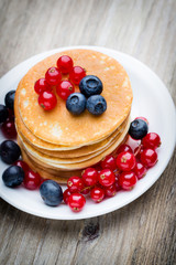 Stack of pancakes with blueberry and fresh berry.