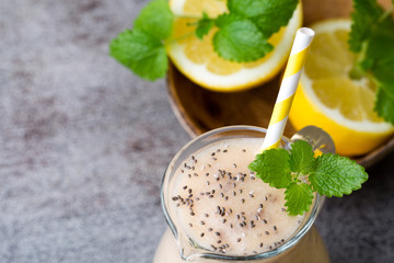 Banana and lemon smoothie, on the grey  background.