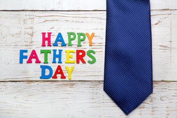 Fototapeta na wymiar Happy fathers day sign and tie laid on wood 