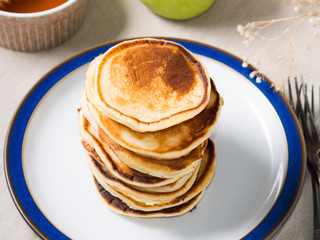 Breakfast with stacked yogurt pancakes on beige table cloth