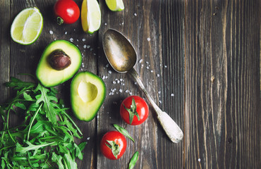 Fresh avocado, lime, tomatoes and arugula with old spoon © Anastasia Izofatova