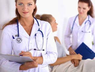 Smiling female doctor with a folder in uniform standing at hospital