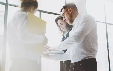 Obraz premium Business team work process. Photo young professionals crew working with new startup project. Project managers meeting. Analyze business plans laptop. Blurred background, film effect