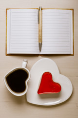 coffee cup cake in heart form and notebook