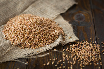 Buckwheat sprinkled on a wooden background