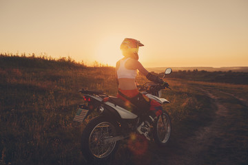Fototapeta na wymiar Woman biker in sunset, female motorcycle.