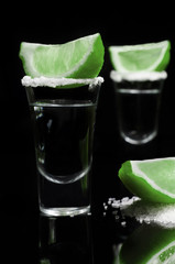 Tequilla in a glass on a reflective black background