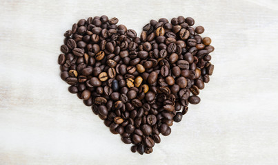 Heart from coffee beans on wooden background