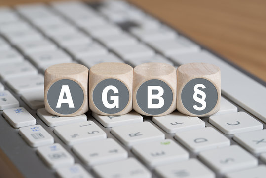 Würfel mit Abkürzung AGB und Paragraph Symbol auf einer Tastatur