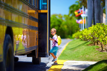 cute kid are getting on the bus, ready to go to school - obrazy, fototapety, plakaty