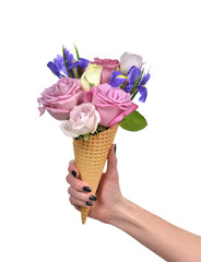 Woman hand holding roses and iris flowers in waffle cones close