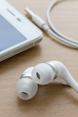 white earphones on wood background