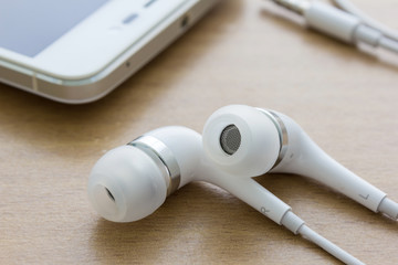 white earphones on wood background