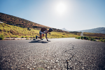 Female skater practicing skateboarding on rural roads © Jacob Lund
