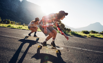 Young friends longboarding down the road © Jacob Lund
