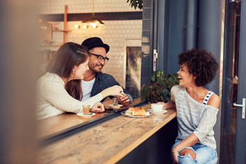Happy young friends meeting in a coffee shop
