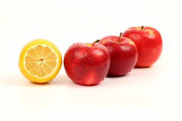 cut a lemon and three apples on white background