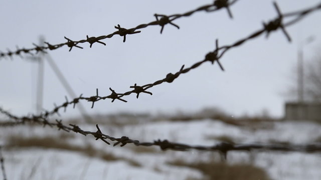 Barbed wire fence, wire sways in the wind
