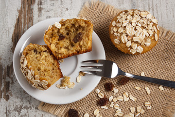 Fresh muffins with oatmeal baked with wholemeal flour on white plate, delicious healthy dessert