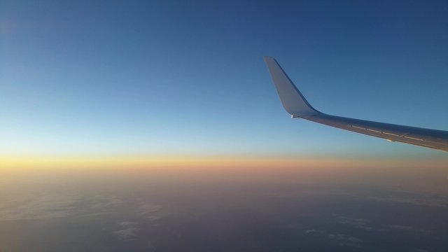 View of an aircraft wing during flight at sunset