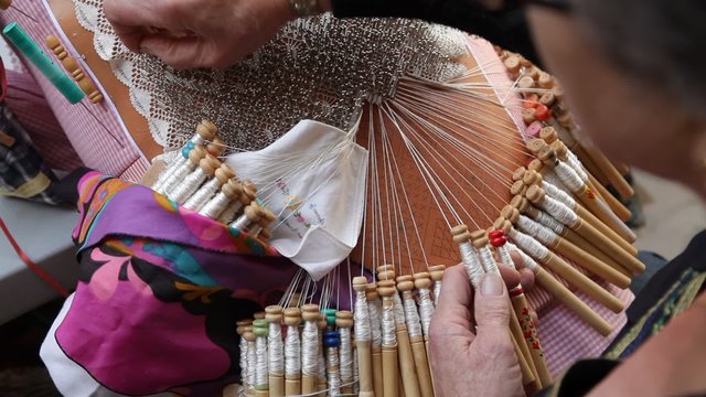 Senior woman working at lace bobbin handicraft