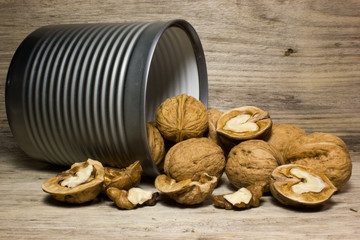 Walnut in shell in tin on wooden background