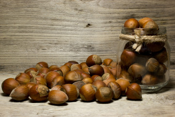 Hazelnut in shell in glass jar on wooden background