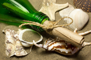 Message in a bottle. A roll of paper in a bottle on the sand. Sea shells.
