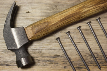The hammer and nails on wooden background