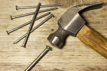 The hammer and nails on wooden background
