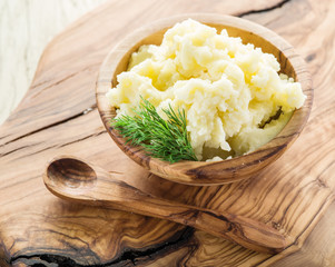 Mashed potatoes in the wooden bowl on the service tray.