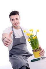 handsome young man gardener posing with flowers and isolated on white background