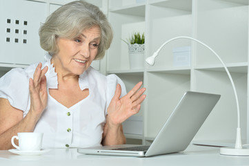 Elderly woman working on laptop