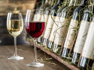 Glass of red wine and wine bottles on the background.
