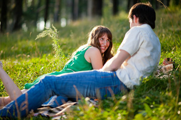Naklejka na ściany i meble Young couple in love outdoor.Stunning sensual outdoor portrait of young stylish fashion couple posing in summer in field