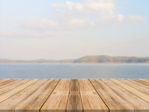 Fototapeta Vintage wooden board empty table in front of blue sea & sky background. Perspective wood floor over sea and sky - can be used for display or montage your products. beach & summer concepts.