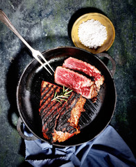 fried steak in a frying pan on a dark background