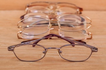 Closeup of glasses with many eyeglasses in background