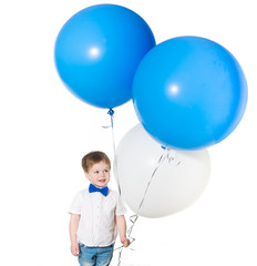 Fototapeta na wymiar Little boy holding a bunch of colored large balloons